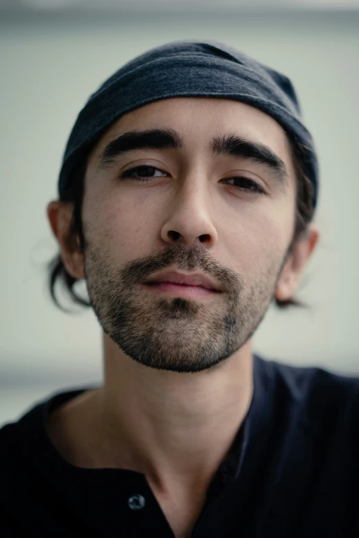 a man with long hair, a shirt and a hat on