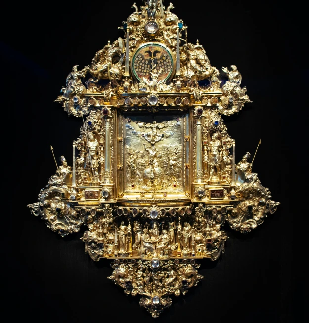 a golden clock with an ornate face surrounded by stars