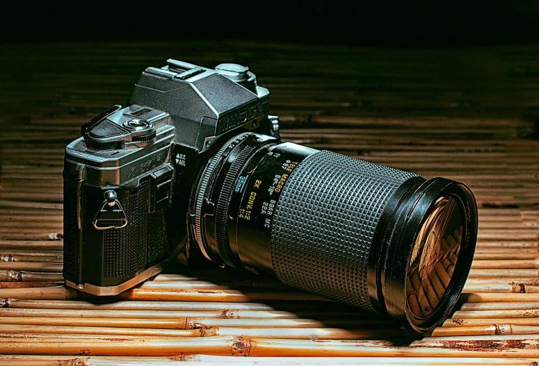 a camera and lens sitting on a bamboo mat