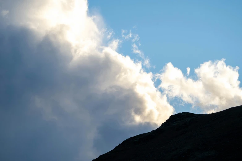 cloud covered mountain and clear blue sky with sun light