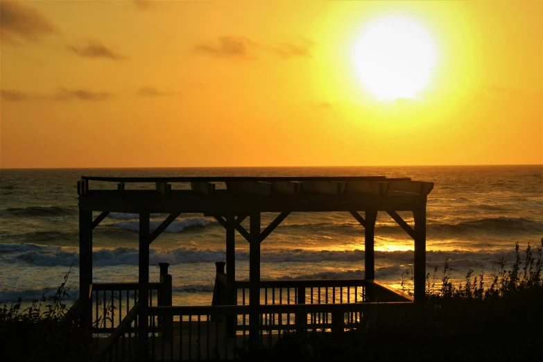 the sun rises over a sandy shore line