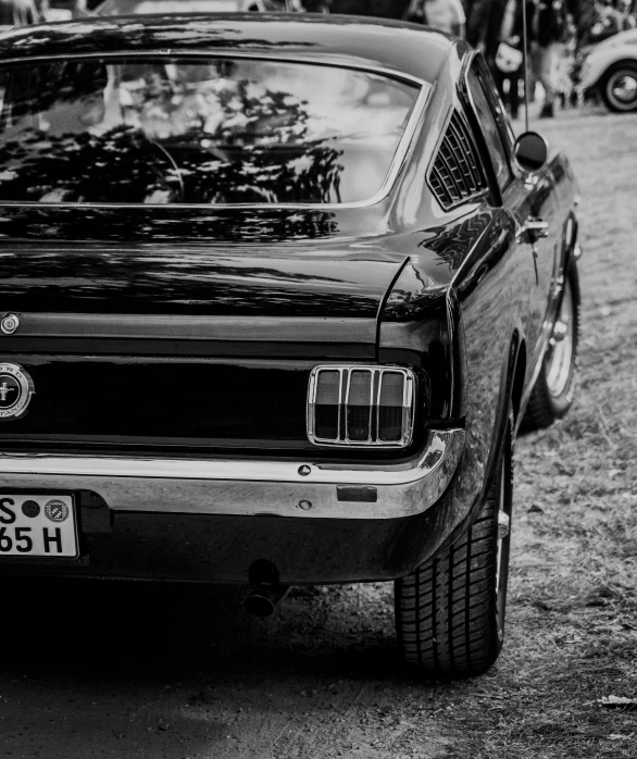 a classic american muscle car parked next to people