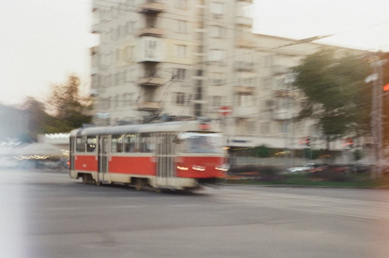 a red and silver tram traveling down the street