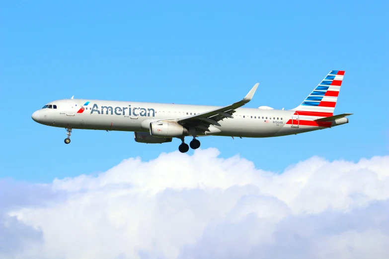 the american airline is in mid - flight with it's landing gear down