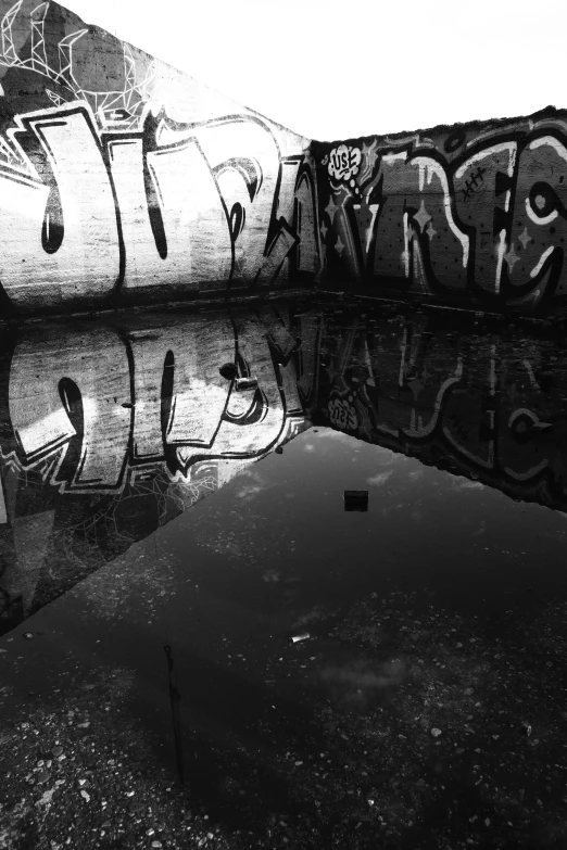 a man walking past graffiti covered walls next to water