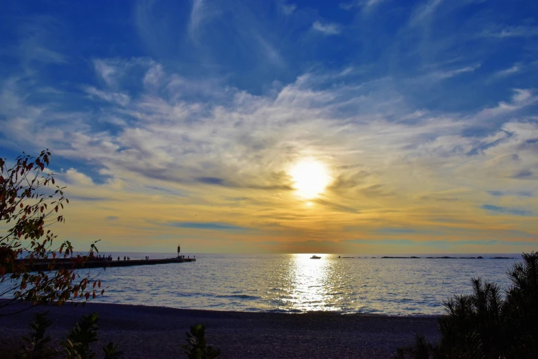 a body of water surrounded by trees and a cloudy sky