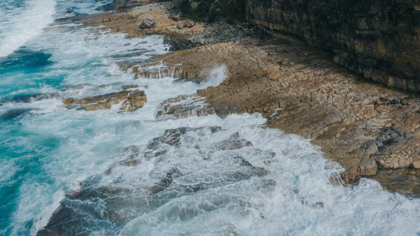 this is an aerial view of ocean waves crashing over a rock wall