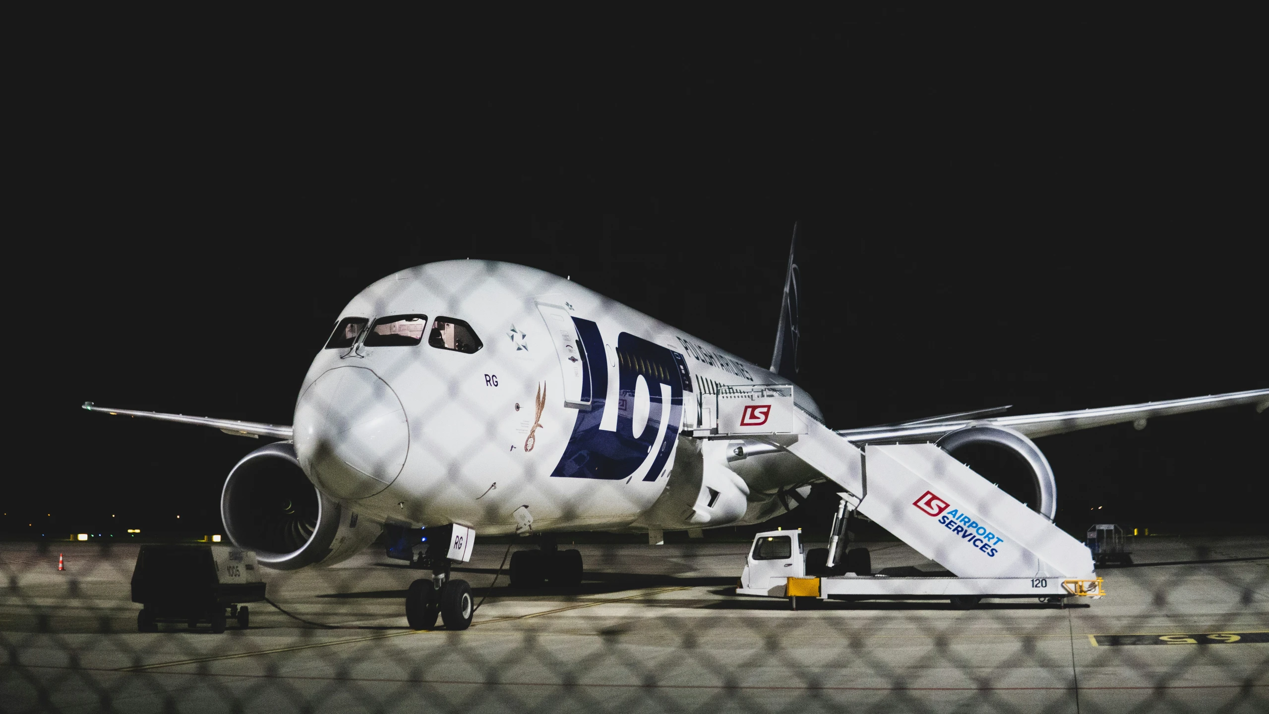 a commercial airliner parked on the tarmac at night