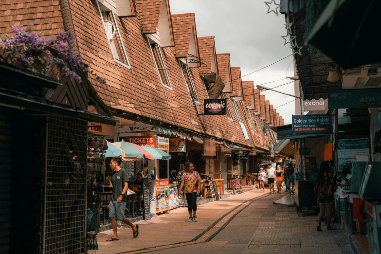 a narrow city street with people shopping