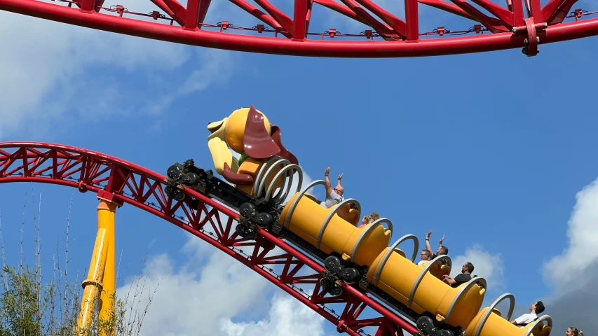 roller coaster ride with riders in motion and cloudy sky