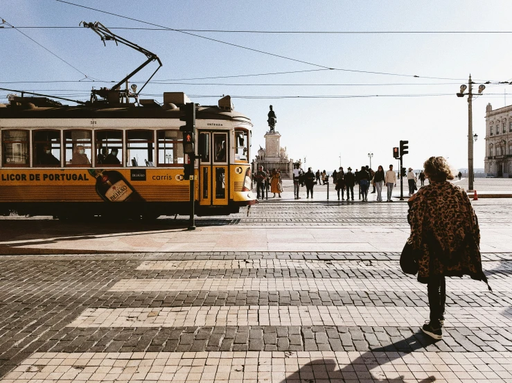 a yellow cable car is parked on the street