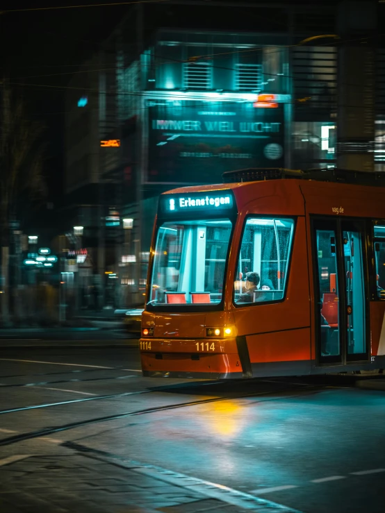 a trolly at night moving past people in the street