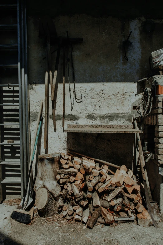 there are firewood piled on the floor by a brick