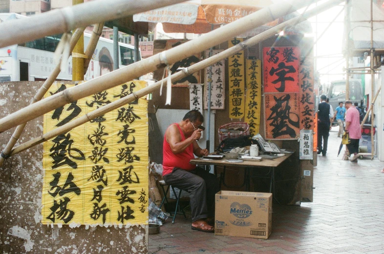 a man on the phone at a desk with asian writing