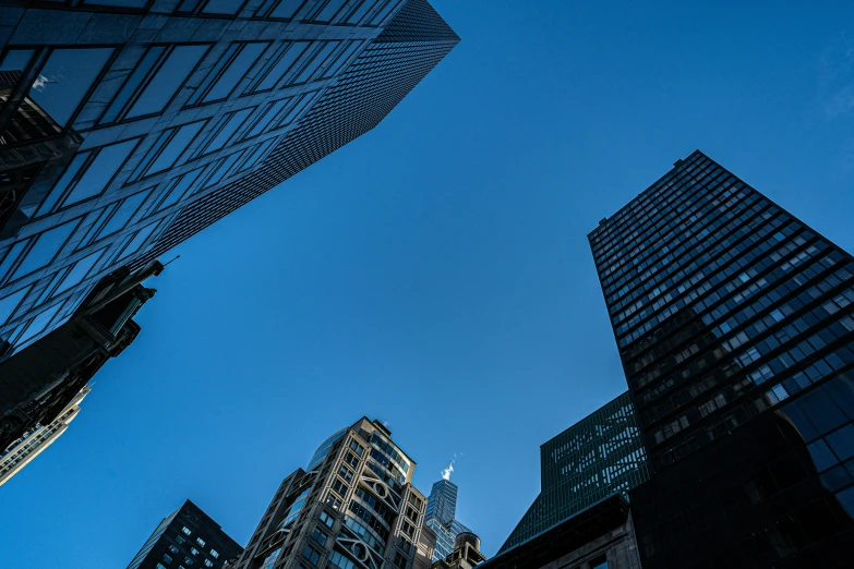 three very tall buildings near one another in the city