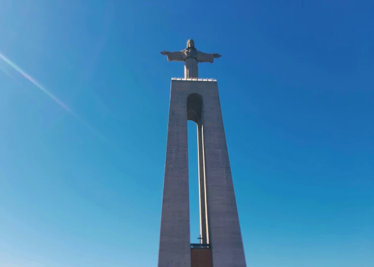 a monument with a statue on top in the middle of the day