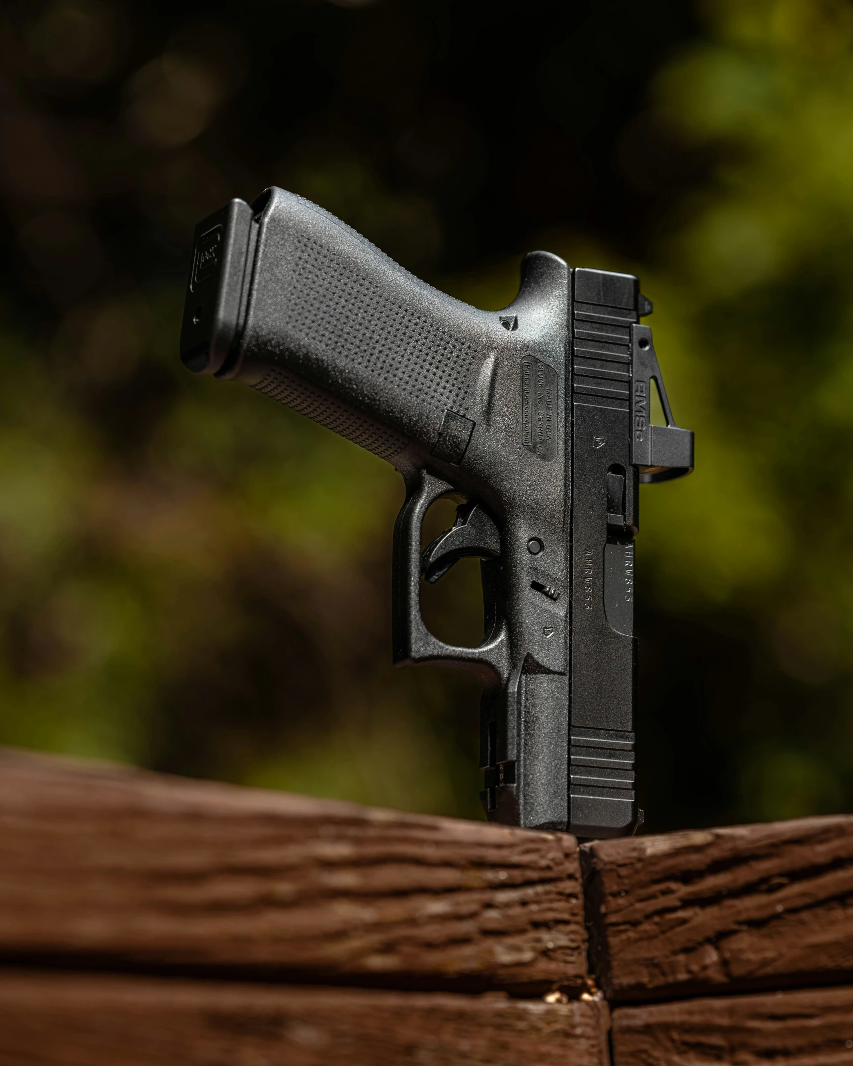 a gun placed on top of a wooden fence