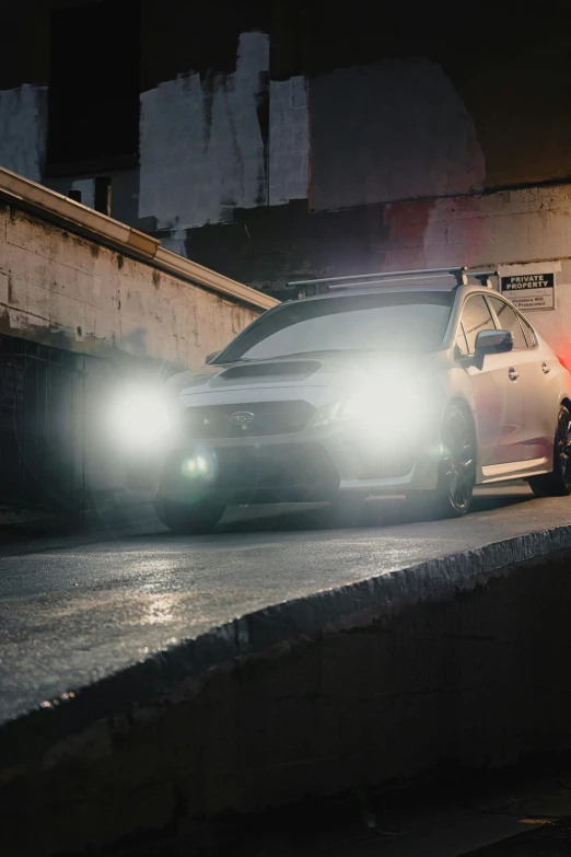 the small car is driving on the street at night