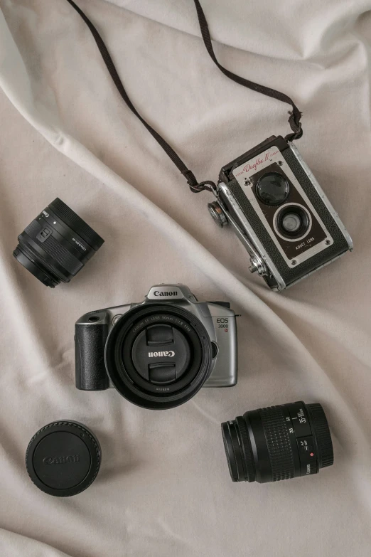 a couple of different types of cameras are laid out on the blanket