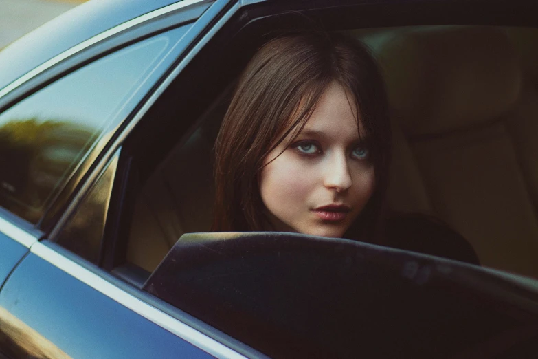 a woman that is sitting in the passenger seat of a car