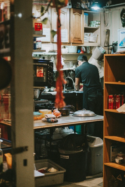 a view into a large commercial kitchen with workers preparing food