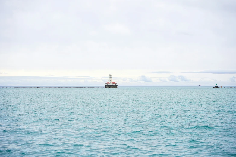 a lone boat sailing across an ocean with sailboats in the distance