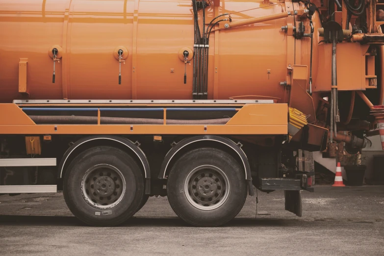 an orange and black truck is parked on a street