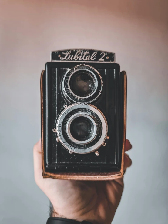 a man holding an old vintage film camera