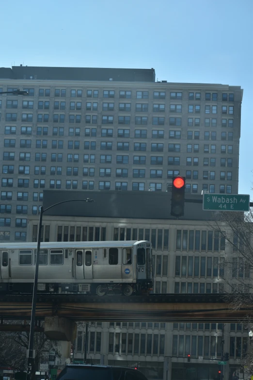 a train passing under a traffic light on a bridge