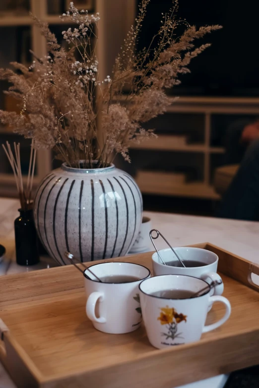 two cups with a spoon and cup on a tray