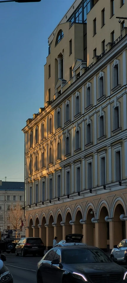 cars are driving down a street in front of a very old building