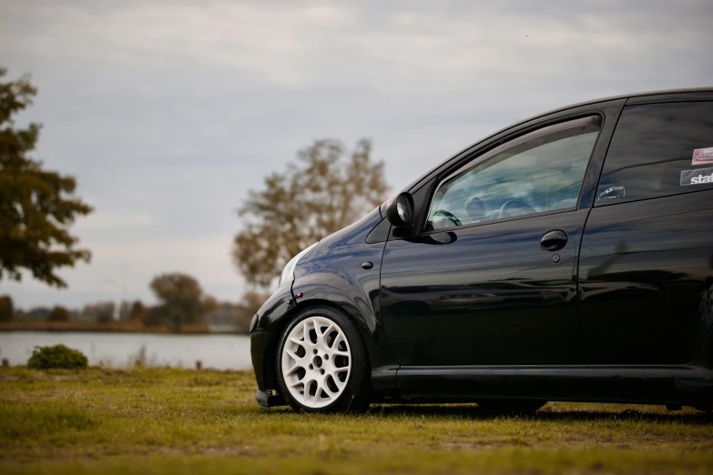 a car parked on grass near water