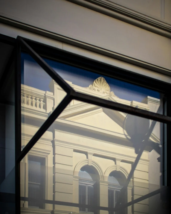 a building reflected in a window near the street corner