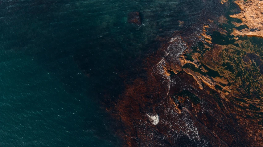 an ocean seen from above with a boat on the water