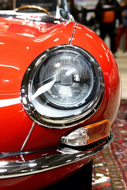 a close up of the front end of a vintage red sports car