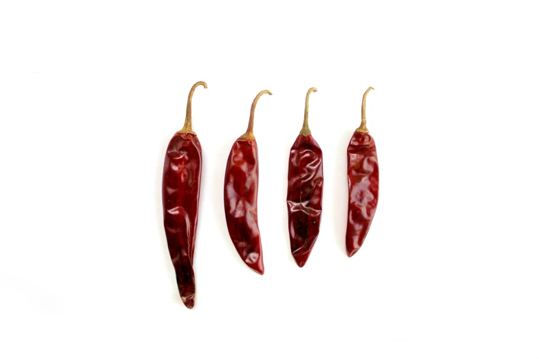 three chilli peppers lined up in rows against a white backdrop