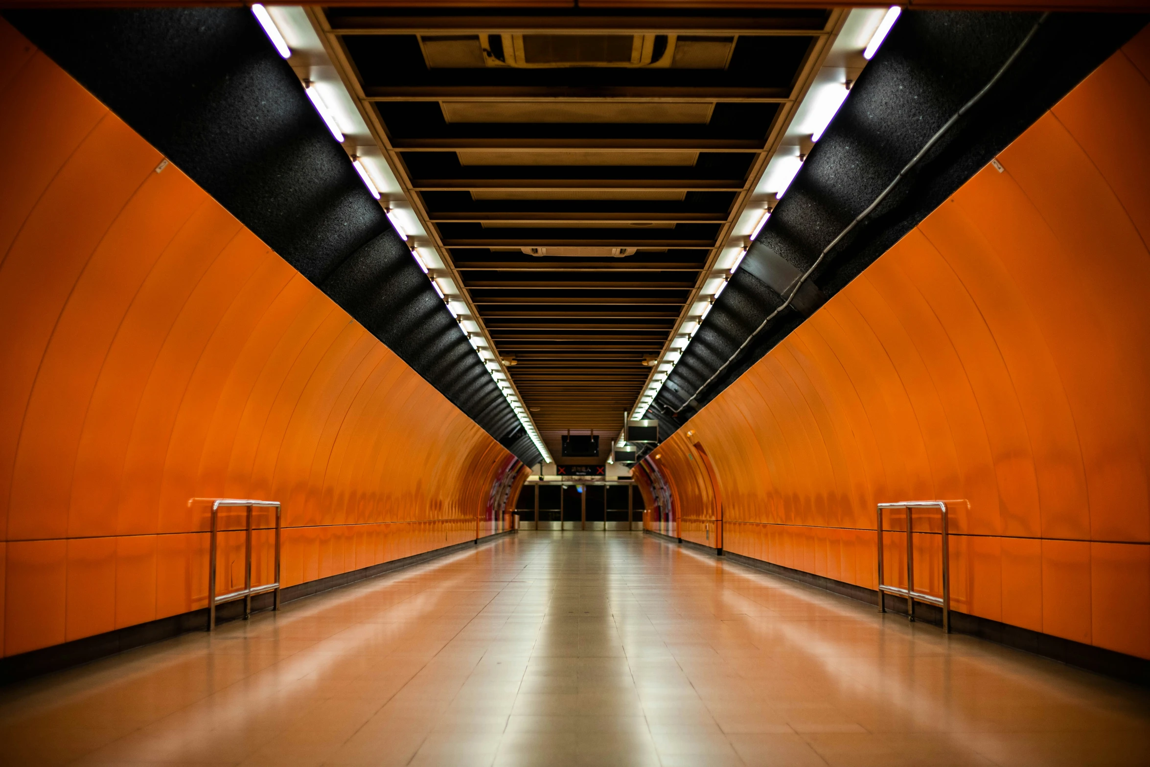 a long tunnel with two people walking inside it