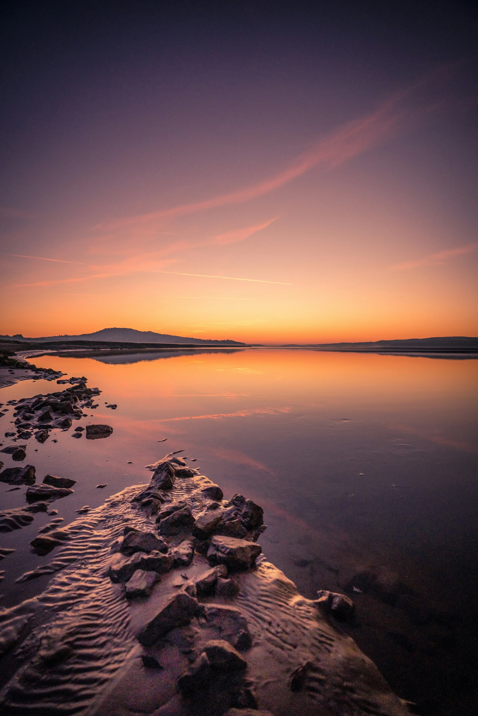 a lake with water and rocks on the side