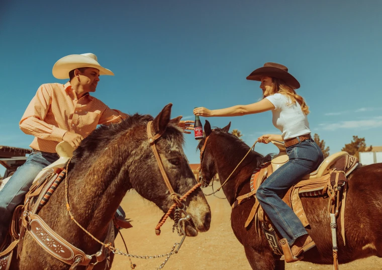 a couple riding horses with western hats on