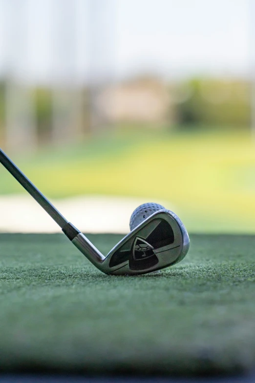 a small ball is lying on the golf putter