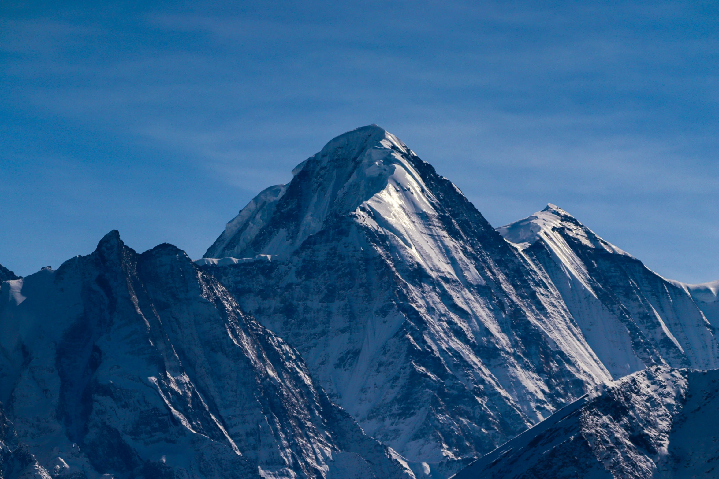 mountains with a snow covered peak are shown against the blue sky