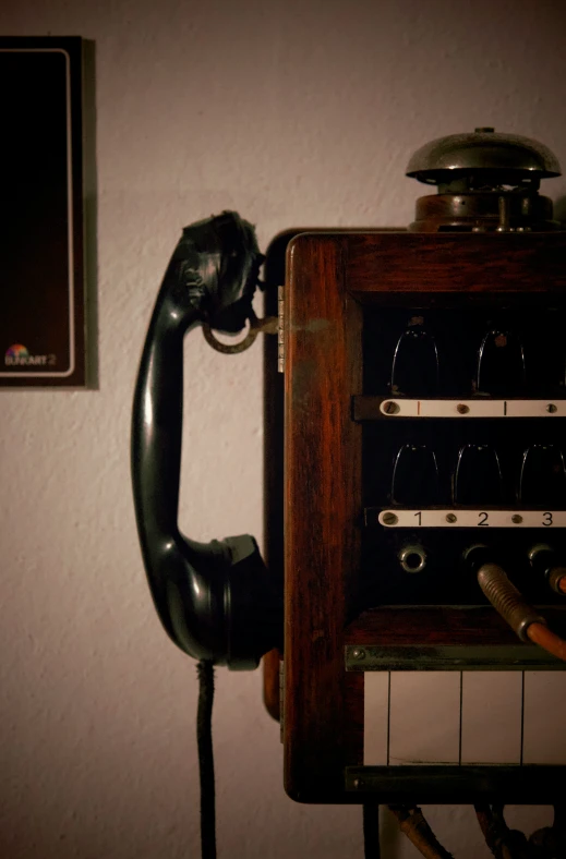 an old telephone sitting next to a wine glass rack