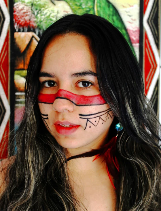 a woman in her native indian clothing with the face painted to look like an american flag
