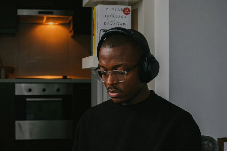 a man in a black shirt and headphones using a laptop