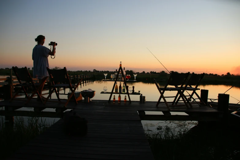 a woman holds her fishing rod near the end of a pier