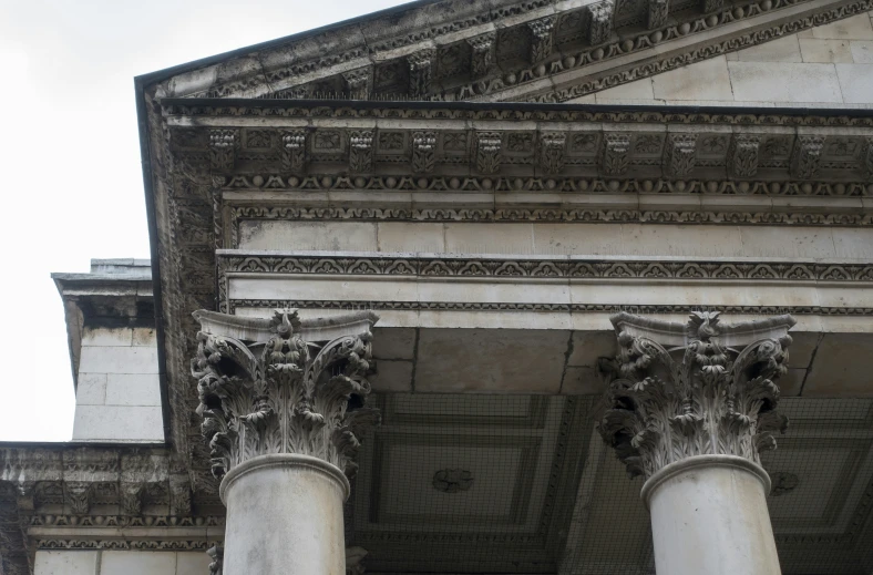 two tall ornate columns in front of a stone wall