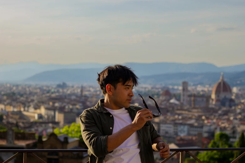 an asian man holds up a pair of scissors to his face