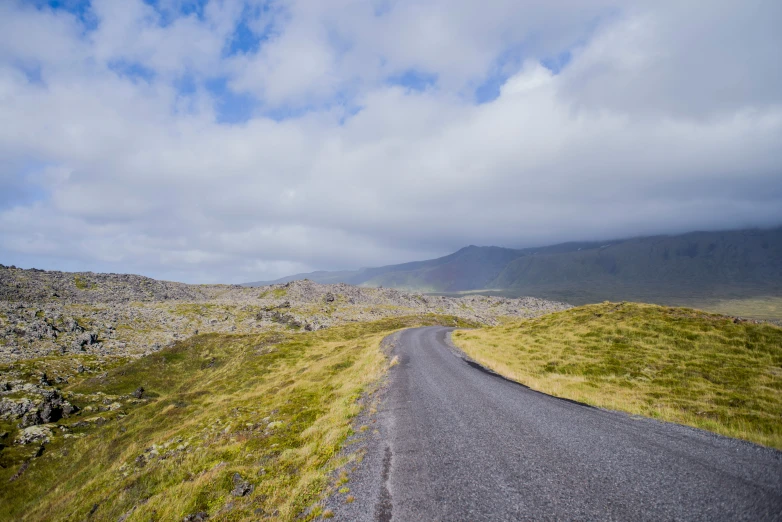 a scenic road leading to some mountains and boulders