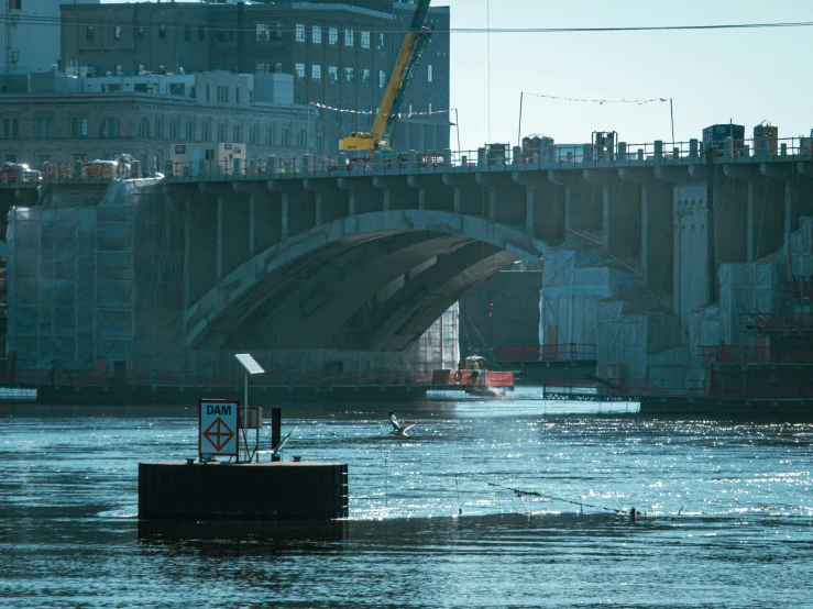 a bridge spanning over a river next to a tall building