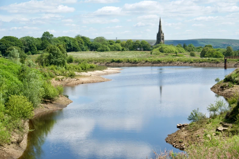 a large lake in a field with a steeple on it